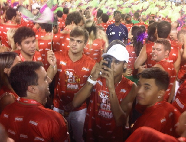Cercado de amigos, Neymar fotografou com o próprio celular e mandou mensagens durante desfile da Mangueira (21/2/2012)